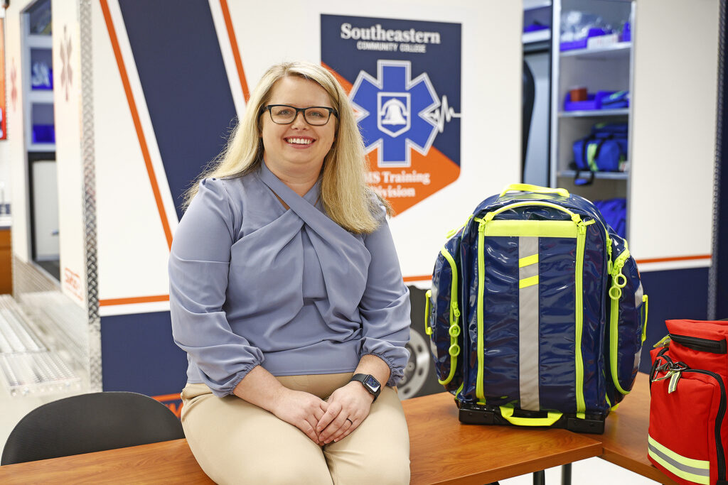 Alex Barnhill Lee sits on a table in the EMS lab.