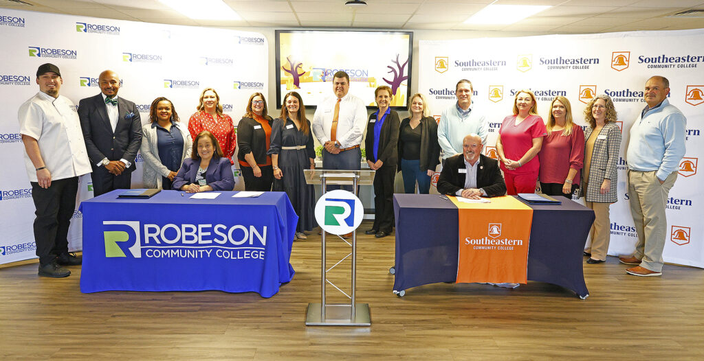 SCC and RCC representatives stand together with the signed agreements.