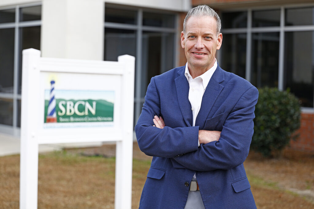 Nathan Moore stands near the Small Business Center sign at SCC.