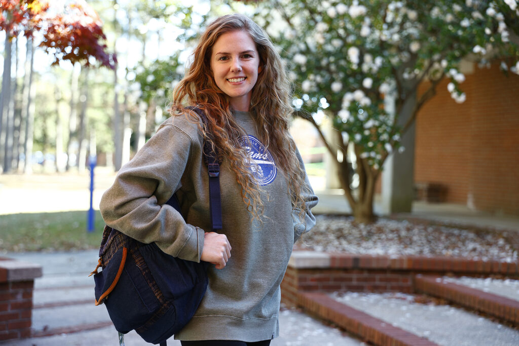 Grace Smith smiles at the camera in front of M building at SCC.