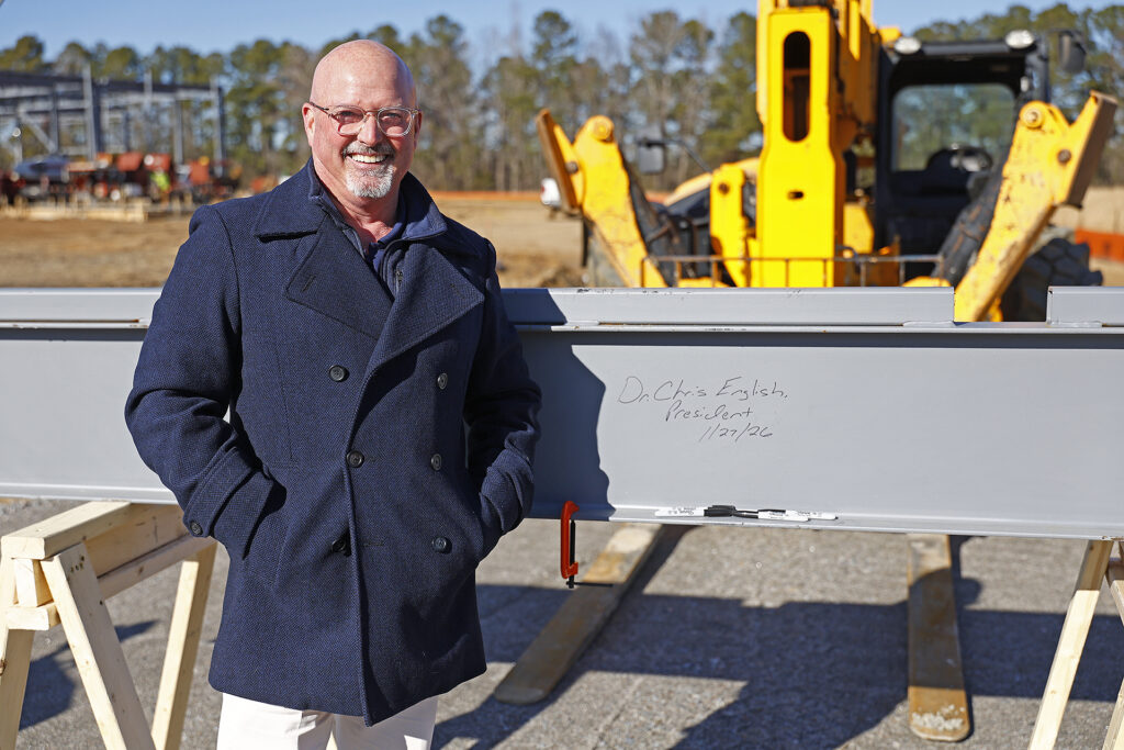 SCC President Dr. Chris English smiles after signing the steel beam at the construction site.