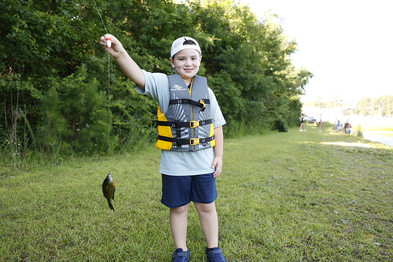 Kid participating in fishing activity with College4Kids