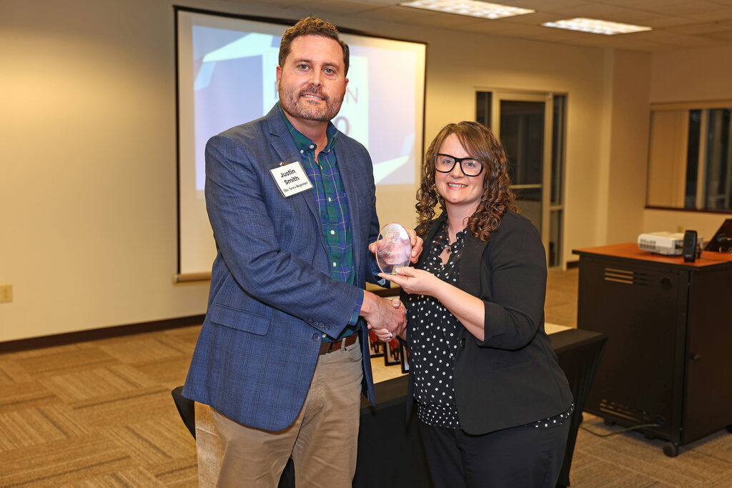 Tiffany Price stands with Justin Smith to accept her Fifteen Under 40 trophy.