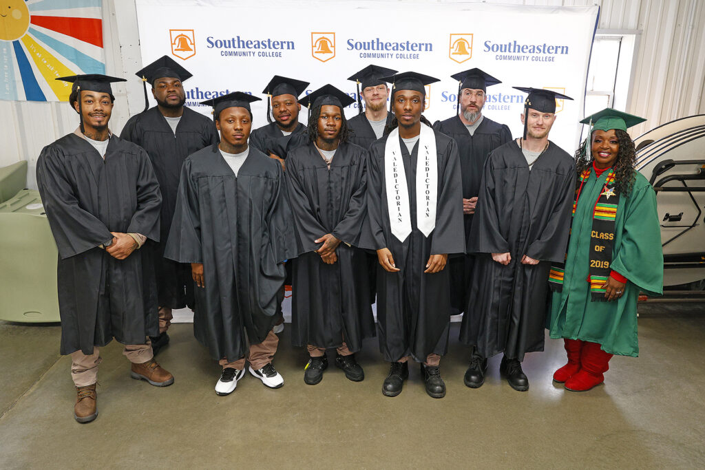 Columbus Correctional Institution offenders stand with their instructor after their high school equivalency diploma graduation ceremony.