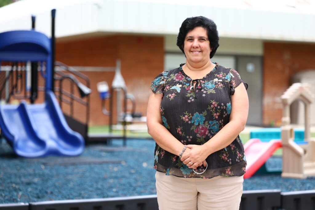 Rita Bretones, Child Development Center Director, stands on the playground.