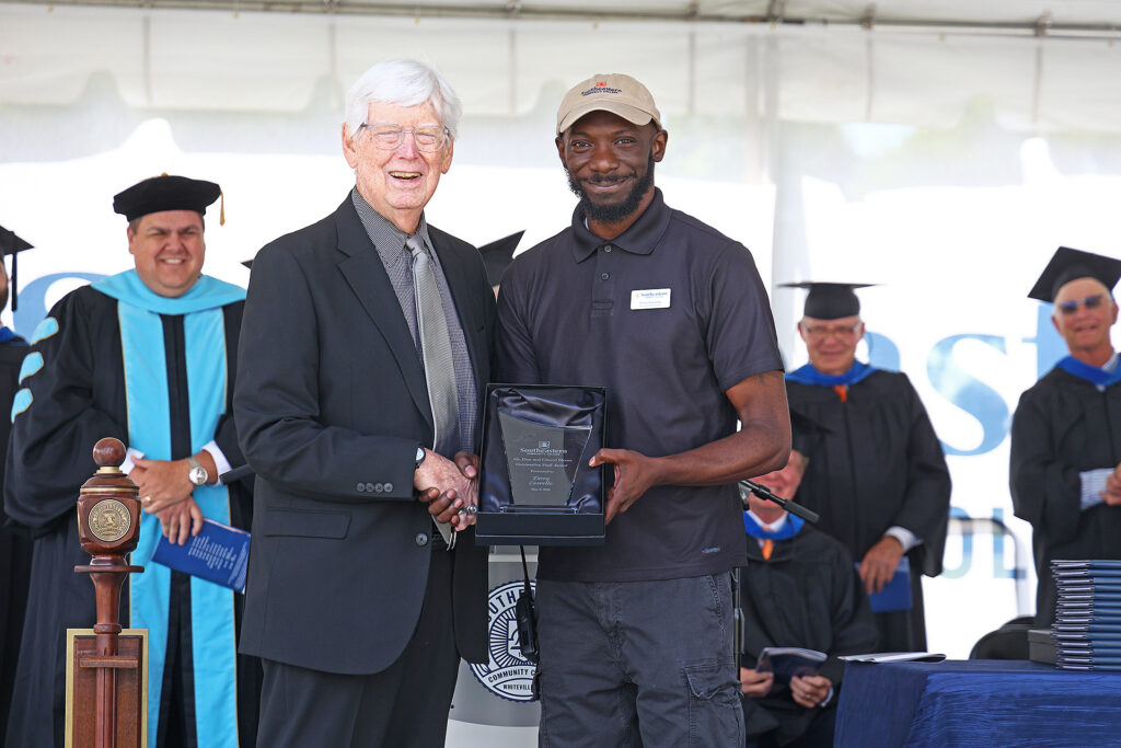 Larry Everette accepts his award from Dr. Dan Moore at the graduation ceremony.