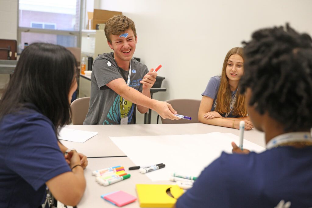 Eli Brown shares a market with his team during a group activity at PILLS Academy.