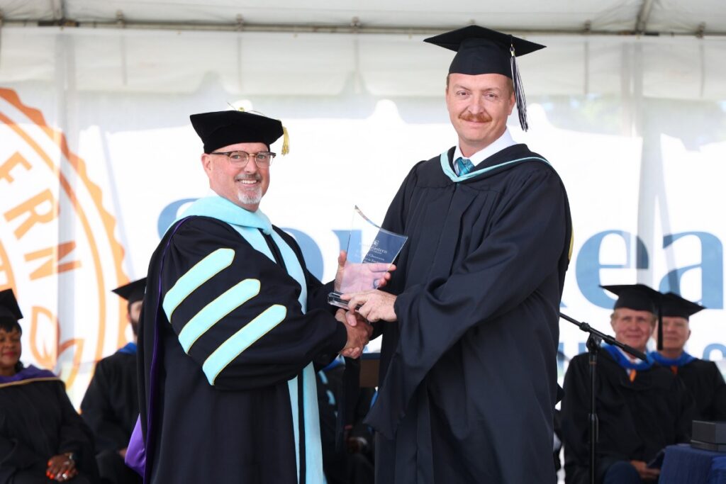 Nicky Hobbs at Graduation 2026 with Dr. English