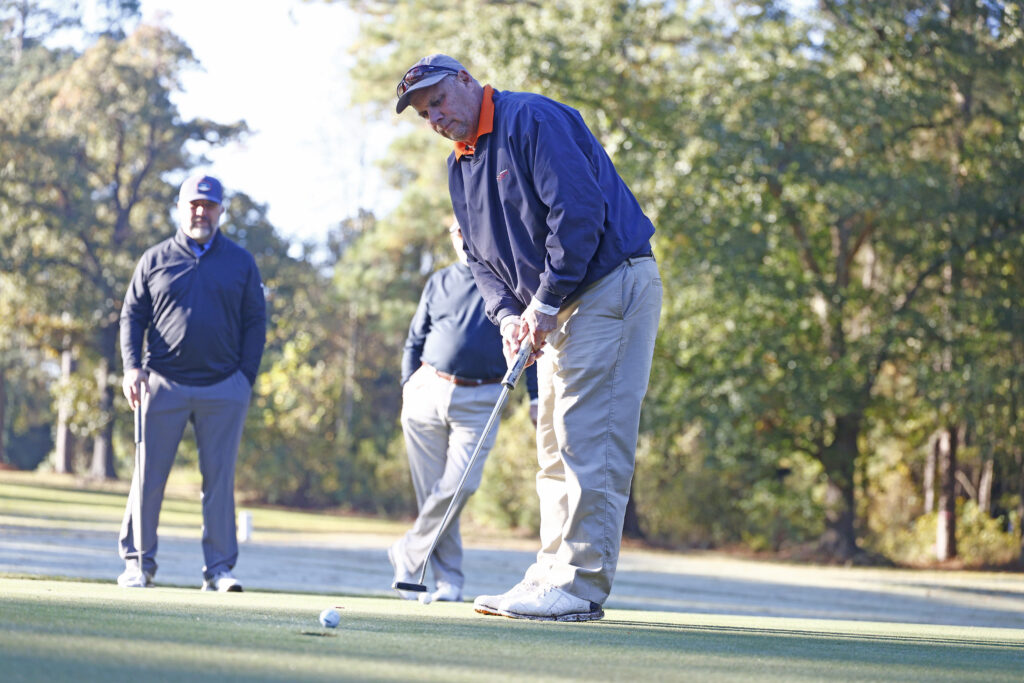 Golf Tournament - Instructor putting on golf green